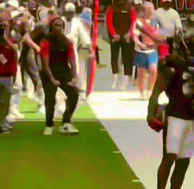 A Blurred Image Of A Crowd Of People Walking On A Green Carpet GIF