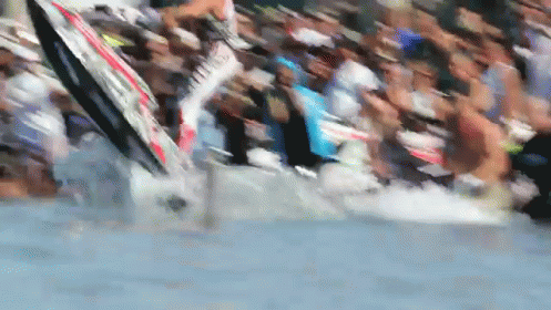 A Blurred Image Of A Crowd Of People Watching A Person On A Surfboard In The Water GIF