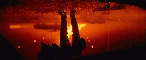 A Blurred Image Of A Fire In A Dark Room With A Red Background GIF