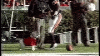 A Blurred Image Of A Football Player Kicking A Ball On The Field GIF