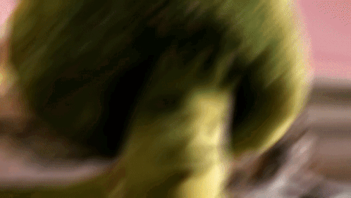 A Blurred Image Of A Green Object With A Pink Background GIF