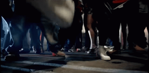 A Blurred Image Of A Group Of People Walking Down A Street GIF