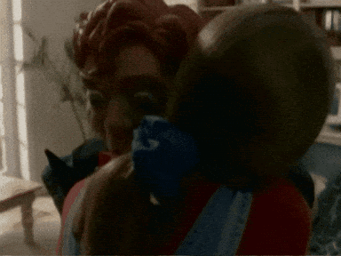 A Blurred Image Of A Man Holding A Child With A Bandana That Says ' A ' On It GIF