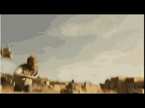 A Blurred Image Of A Man Kneeling In A Field With A Sign That Says ' Ranch ' On It GIF
