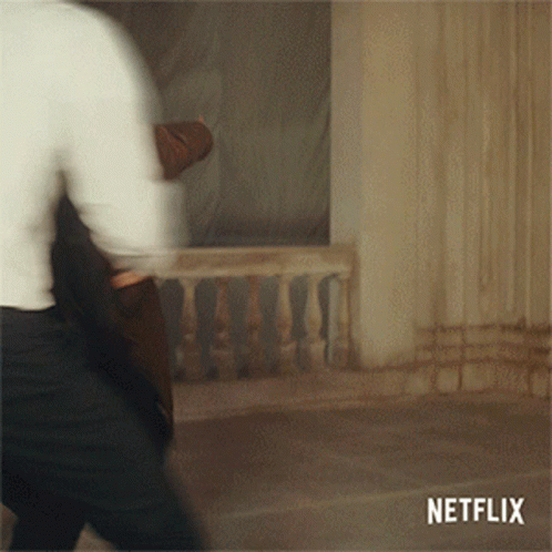 A Blurred Image Of A Man Walking With A Netflix Logo Behind Him GIF