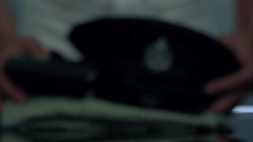 A Blurred Image Of A Person Holding A Black Object In Their Hands GIF