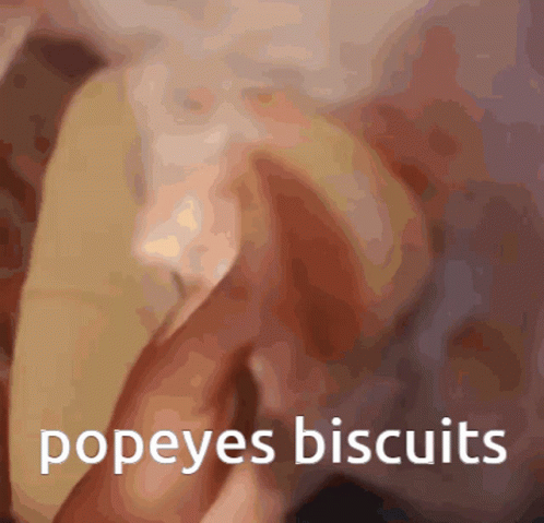 A Blurred Image Of A Person Holding A Popeye 'S Biscuit GIF