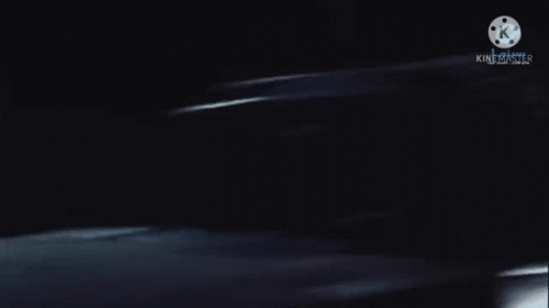 a blurred image of a person in a dark room with a k on the bottom