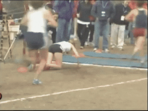 A Blurred Image Of A Person Kneeling On The Ground With A Crowd Behind Them GIF
