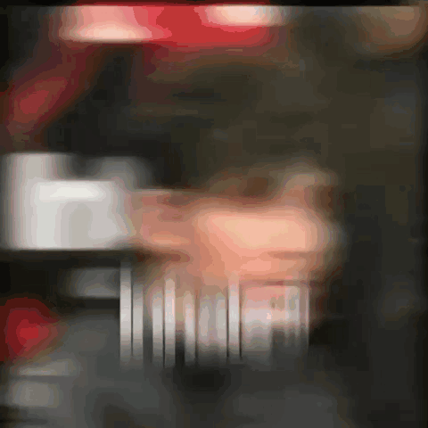 A Blurred Image Of A Person 'S Face With A Red Light Behind Them GIF
