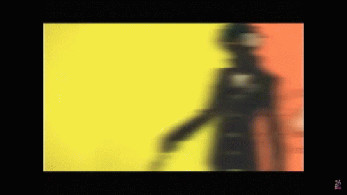 A Blurred Image Of A Person Standing In Front Of A Yellow And Red Background . GIF