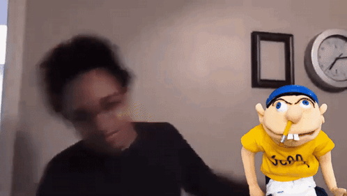 A Blurred Image Of A Person Standing Next To A Puppet With A Yellow Shirt That Says Juan GIF
