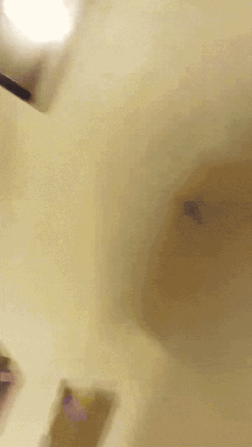A Blurred Image Of A Person Wearing A Yellow Hat GIF