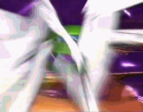 A Blurred Image Of A Purple And Green Colored Object GIF