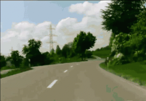 A Blurred Image Of A Road With Trees On The Side Of It GIF