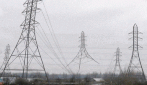 A Blurred Image Of A Row Of Power Lines And Towers GIF
