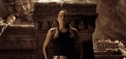 A Blurred Image Of A Woman Holding A Gun In Front Of A Stone Wall GIF