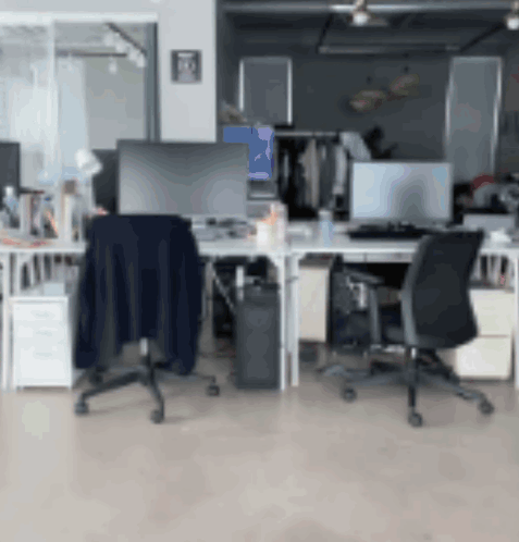 A Blurred Image Of An Office With A Blue Item On The Wall GIF