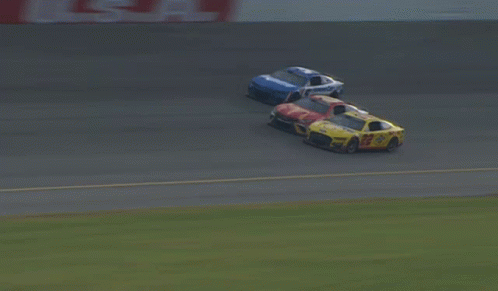 A Blurred Image Of Cars Racing On A Track With A Sign That Says Coca Cola GIF