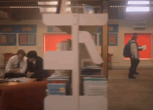 A Blurred Image Of People In A Library With A Sign On The Wall That Says ' A ' GIF