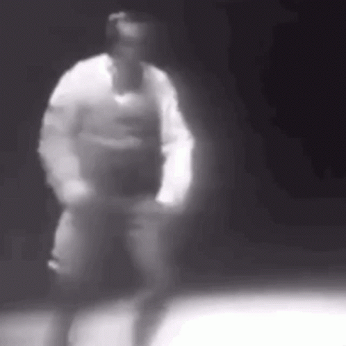 A Blurry Black And White Photo Of A Man Dancing In The Dark . GIF