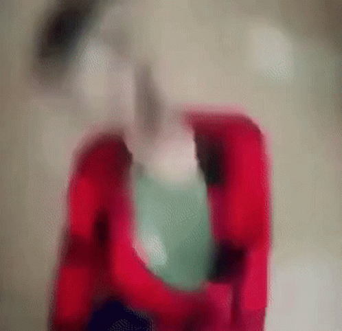 A Blurry Image Of A Person Holding A Green Balloon GIF