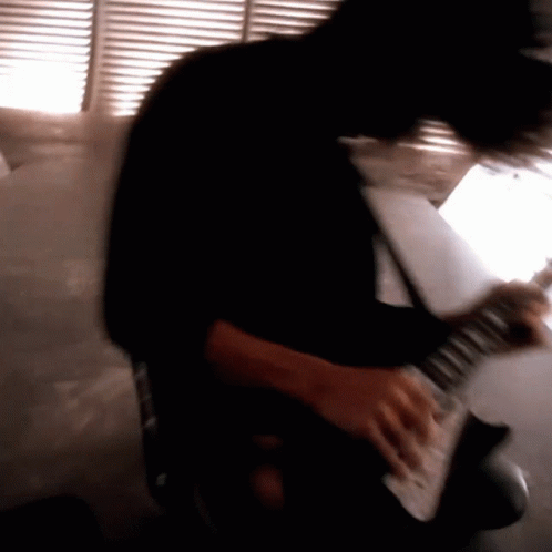 a blurry image of a person playing an electric guitar