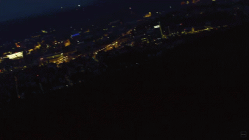 A Blurry Photo Of A City At Night With A Blue Sky GIF