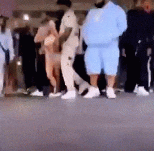 A Blurry Photo Of A Group Of People Standing On A Street . GIF