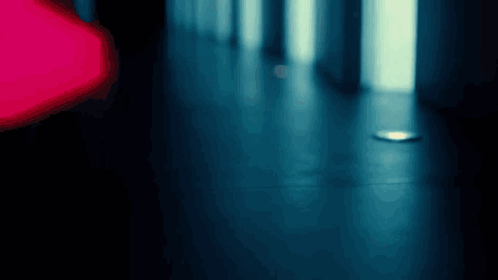 A Blurry Photo Of A Hallway With A Red Light In The Background GIF