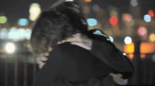 A Blurry Photo Of A Man And Woman Hugging GIF