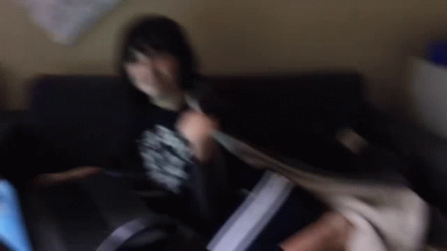 A Blurry Photo Of A Person Sitting On A Couch . GIF