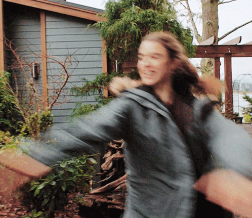 A Blurry Photo Of A Woman Dancing In Front Of A House GIF