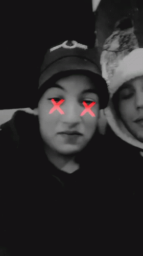 a blurry photo of two people with a red smiley face on their face