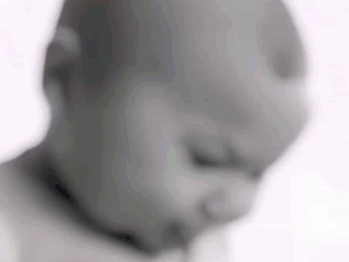 A Blurry Picture Of A Baby 'S Face With A Pacifier In His Mouth . GIF