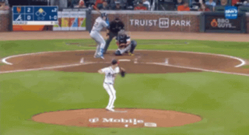 A Blurry Picture Of A Baseball Field With A Scoreboard Behind It GIF
