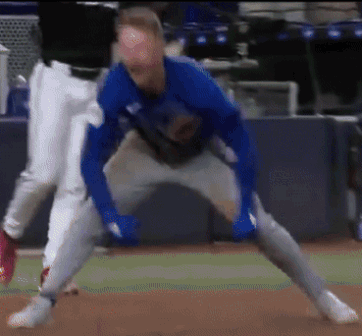 A Blurry Picture Of A Baseball Player In A Blue Shirt GIF
