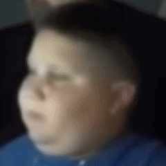 A Blurry Picture Of A Boy In A Blue Shirt With His Eyes Closed GIF