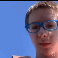 A Blurry Picture Of A Boy Wearing Glasses GIF