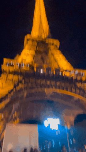 A Blurry Picture Of A Building At Night With A Blue Light Shining On It GIF
