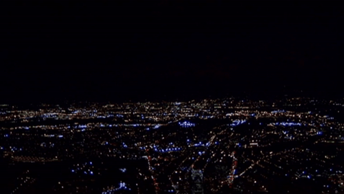 A Blurry Picture Of A City At Night With A Few Buildings Lit Up Including One That Says ' A ' GIF