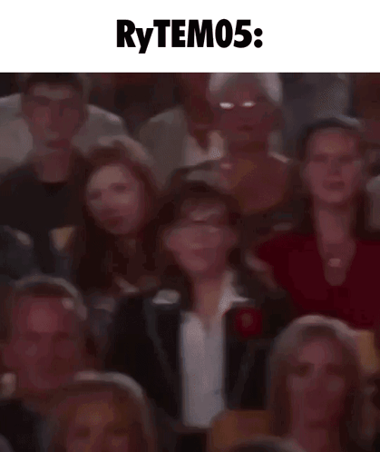A Blurry Picture Of A Crowd Of People Sitting In A Theater With The Words Rytem05 Written Above Them . GIF