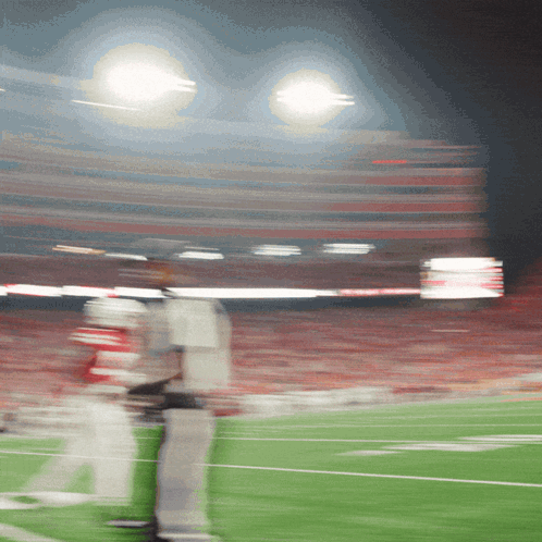 a blurry picture of a football field with a few players