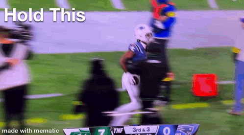 A Blurry Picture Of A Football Game With The Words Hold This In The Corner . GIF