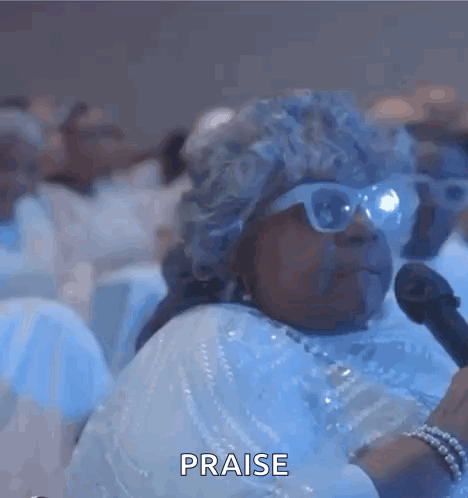 A Blurry Picture Of A Group Of People Sitting In A Room With The Words Praise Written On The Bottom . GIF