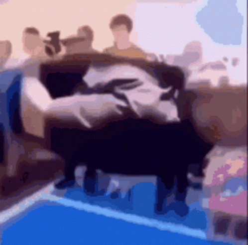 A Blurry Picture Of A Group Of People Sitting On A Couch In A Room . GIF