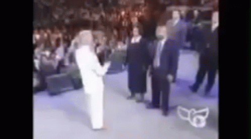 A Blurry Picture Of A Group Of People Standing In A Room . GIF
