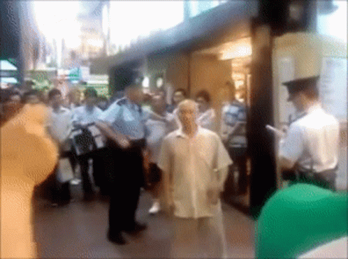 A Blurry Picture Of A Group Of People Standing Outside A Building GIF