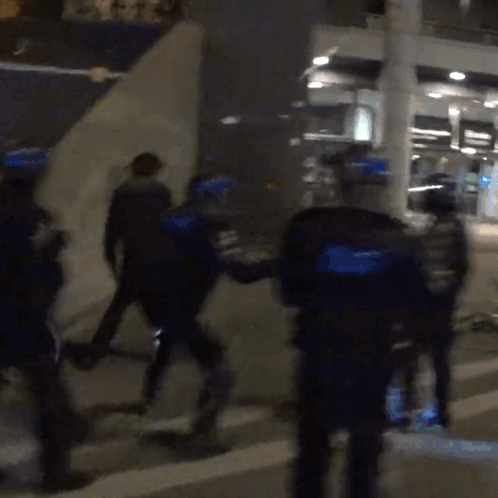 A Blurry Picture Of A Group Of Police Officers In Blue Uniforms GIF