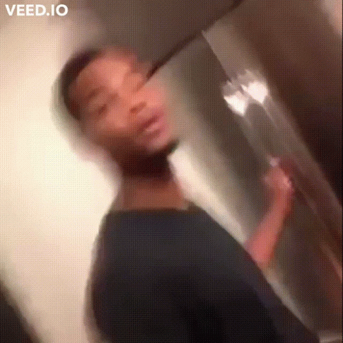 A Blurry Picture Of A Man Brushing His Teeth In A Bathroom GIF